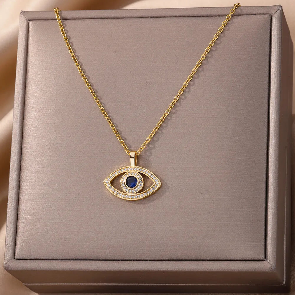 Gold necklace with an eye-shaped pendant on a gray box
